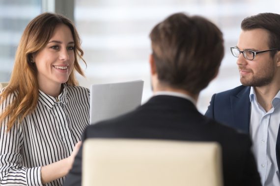 Young,Broker,Businesswoman,Talking,To,Business,Partners.,Woman,Consulting,,Giving businesswoman talking to a client