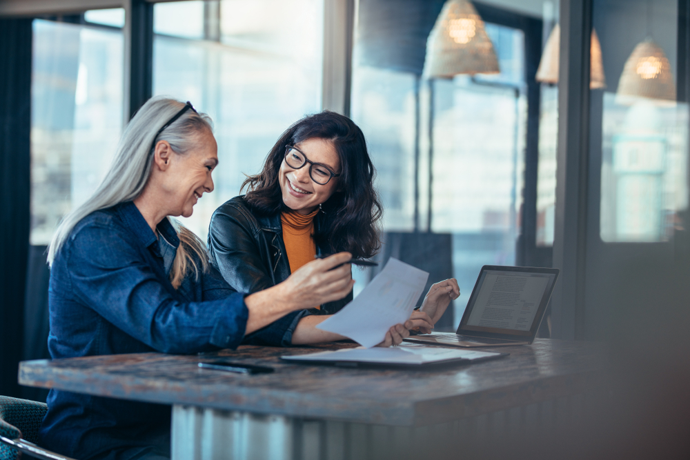 Smiling business women holding contract documents