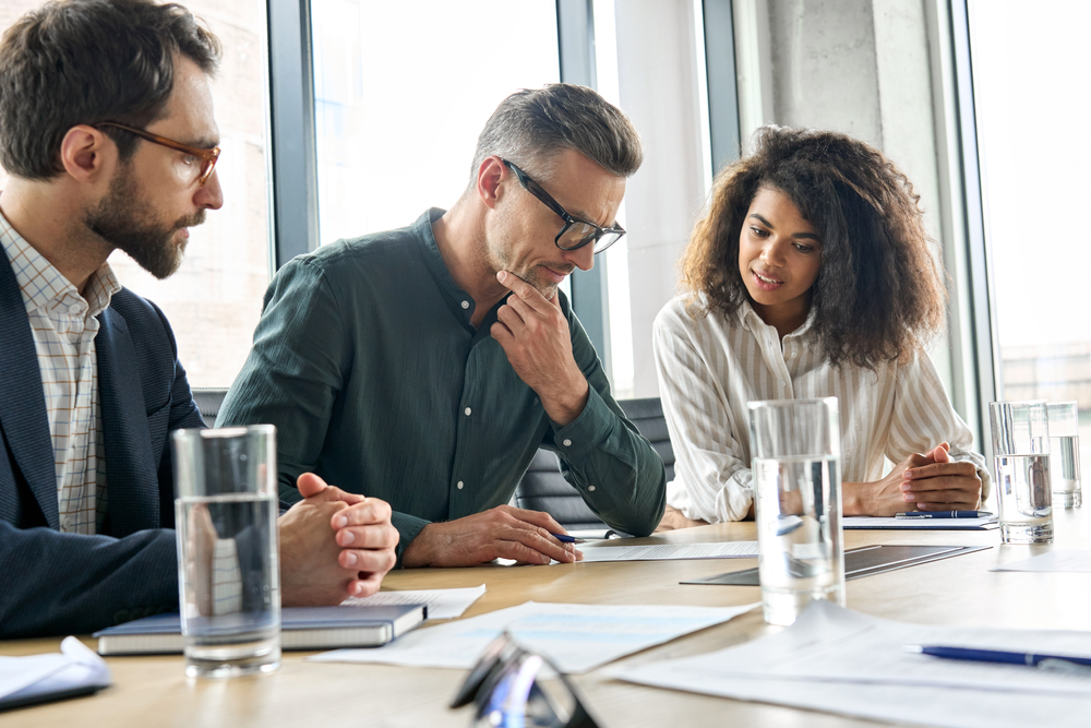 business men and woman thinking and discussing on a table