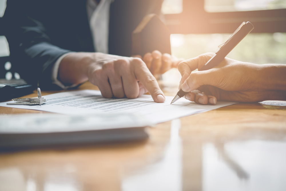 client signing a document with a businessman